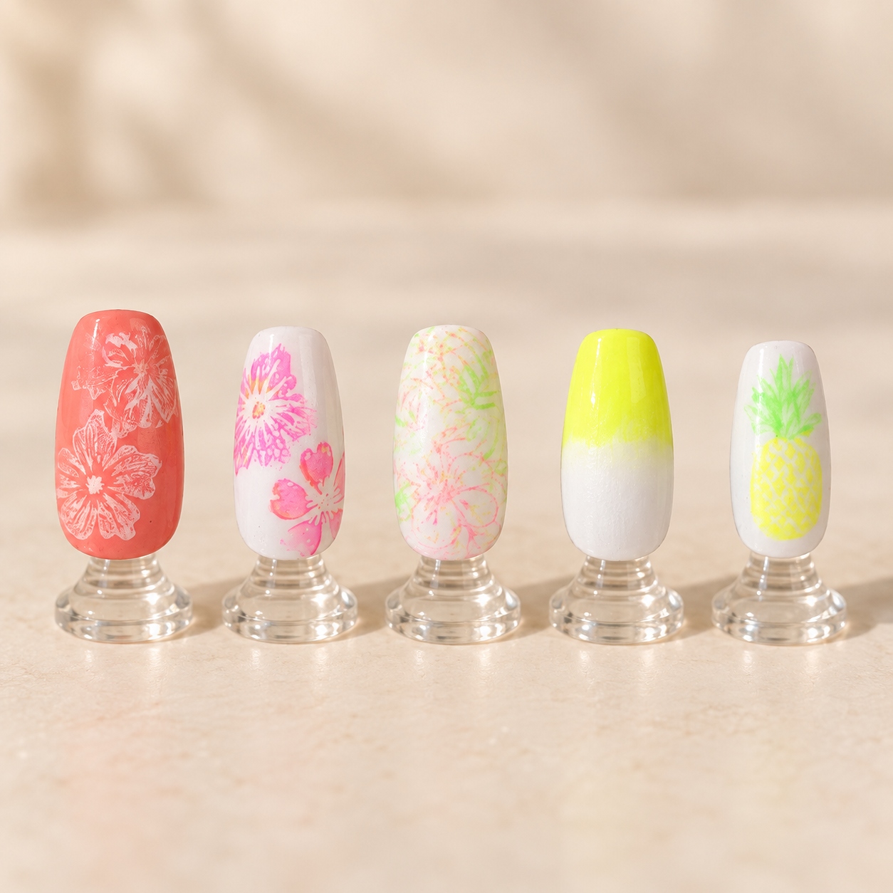 Neon floral and pineapple nail art displayed on clear stands