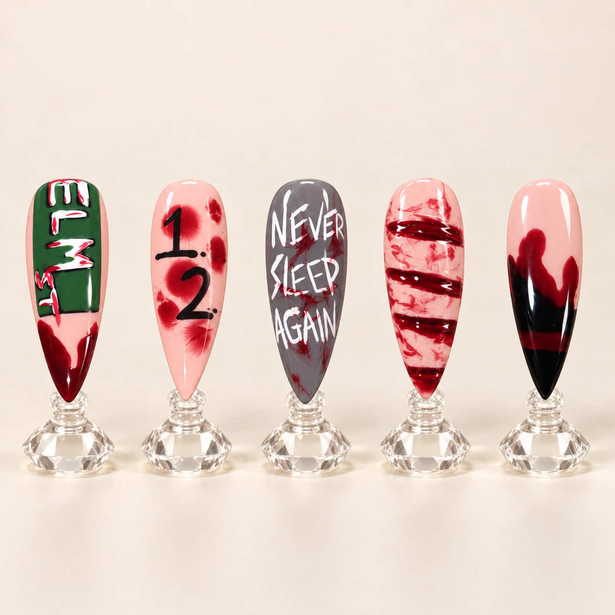 Freddy Krueger inspired horror nail art with Elm Street details blood effects and hand painted lettering displayed upright on clear stands