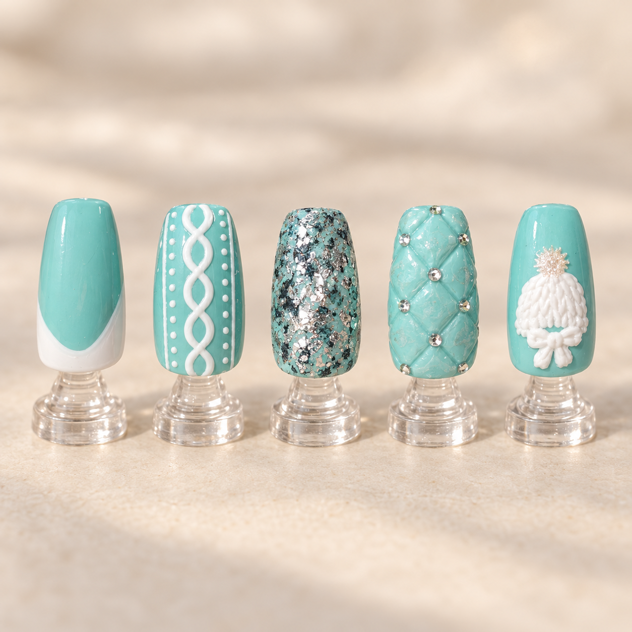 Tiffany blue and white winter nail art with silver glitter quilted texture gems and molded three dimensional accents displayed on clear stands